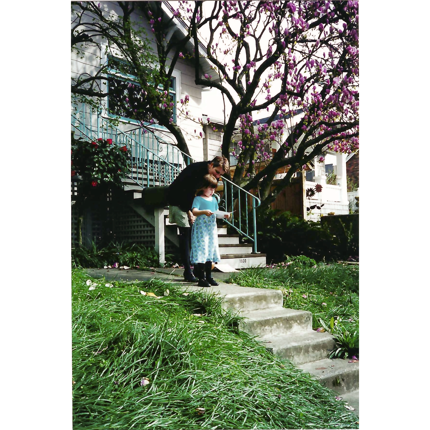Photo of young girl in front of mother reading start of processional, with  mangolia and house in background