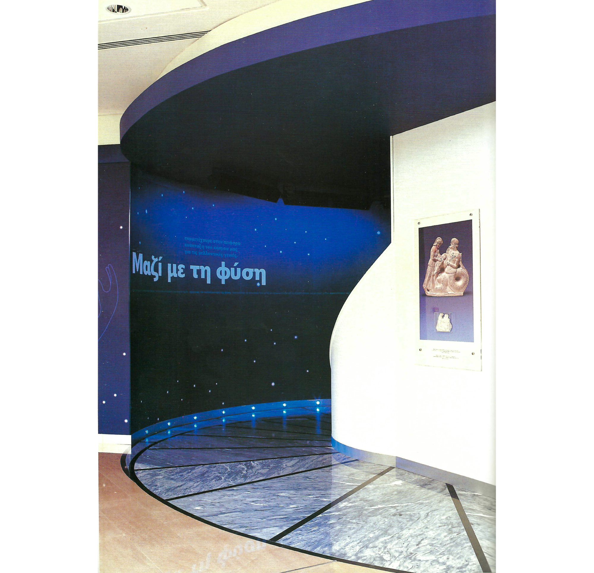 PHoto of exhibit entrance with title in Greek, with stone floor curving right into area with blue walls, stars, and purple ceiling