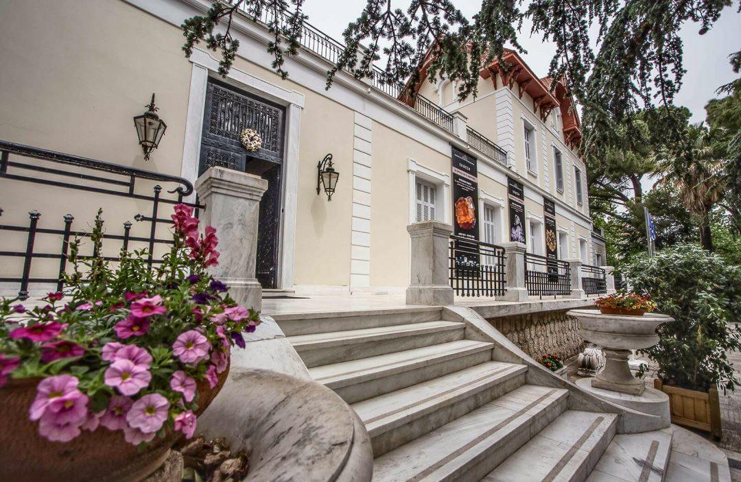 Photo of beige and white museum building with steps leading up from bottom right to middle