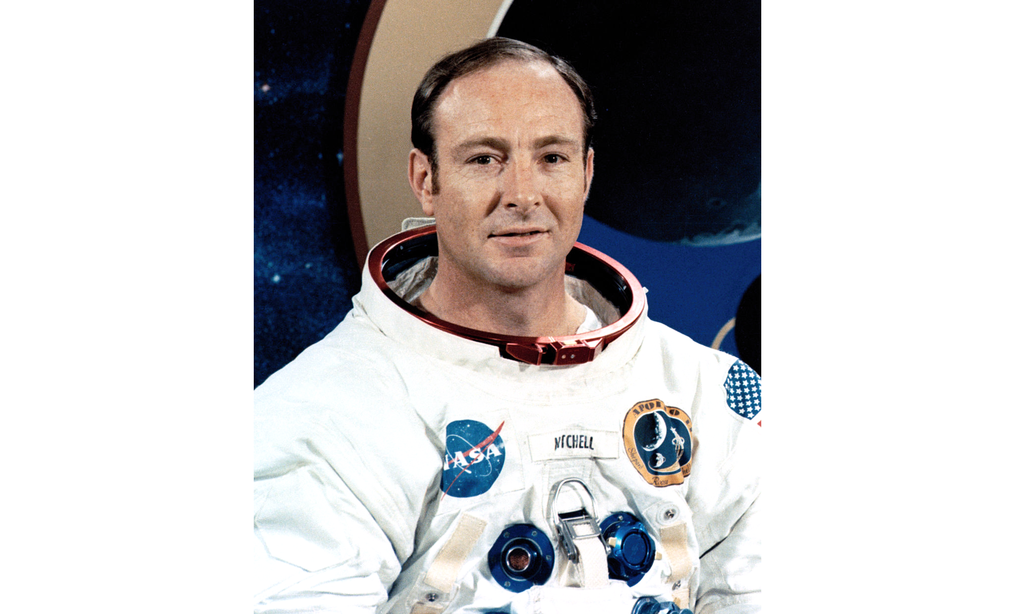 Photo of Edgar Mitchell wearing NASA astronaut suit, with bare head.