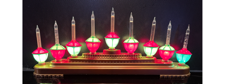 Photo of nine red and green bubble lights arranged on a gold-covered 5-tier ziggurat